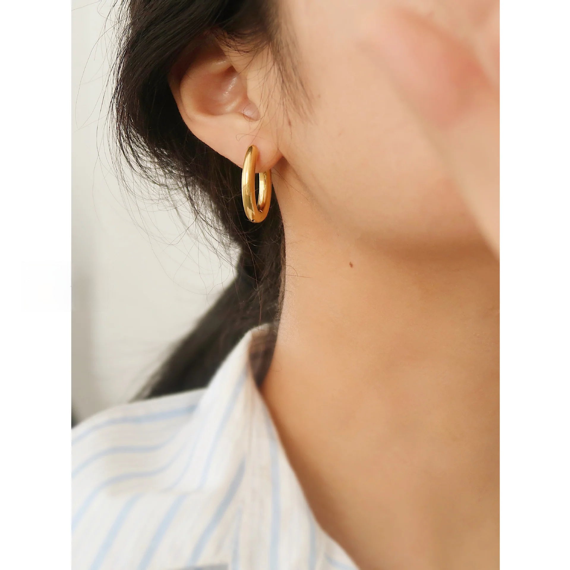 Elegant old money style gold oval hoop earrings on model