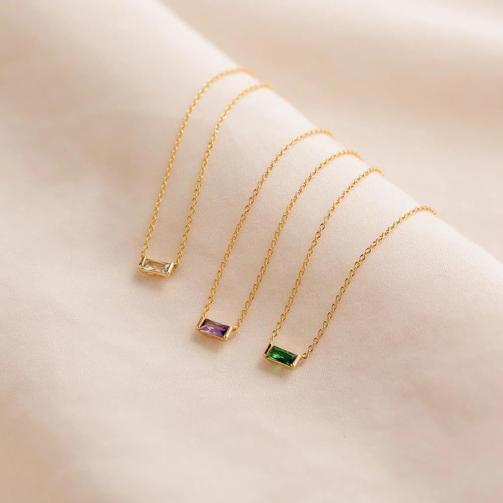 Close-up of minimalist silver clavicle chain with a sparkling square lucky stone purple and green