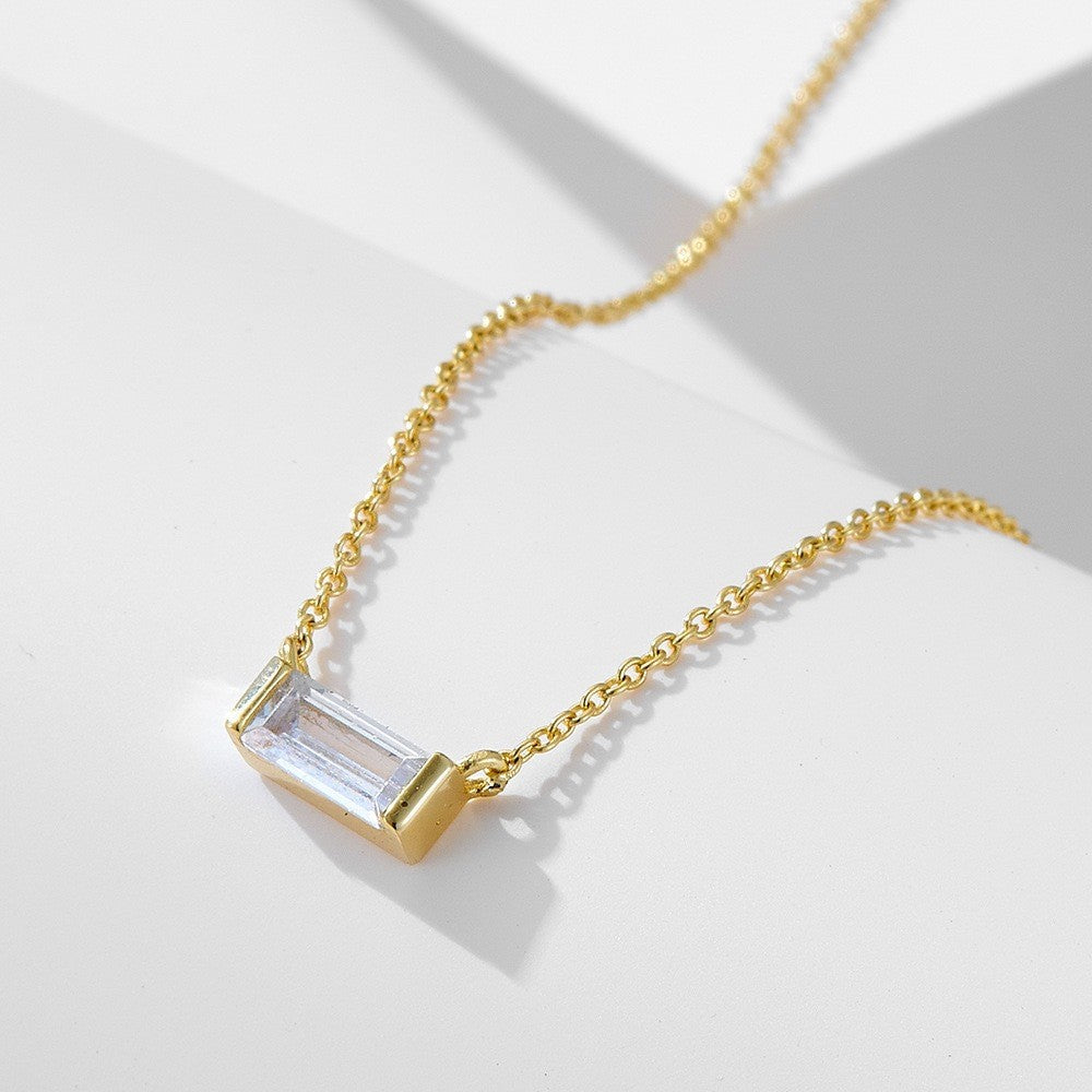 Close-up of minimalist silver clavicle chain with a sparkling square lucky stone