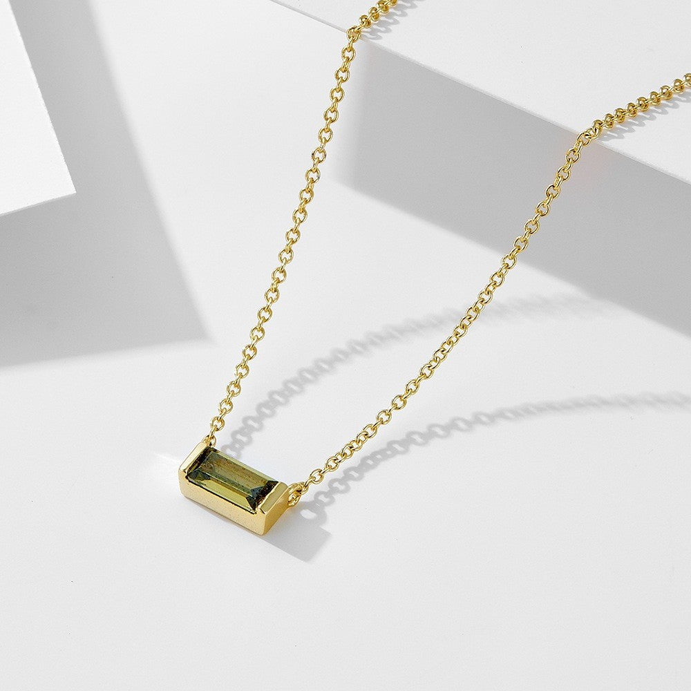 Close-up of minimalist silver clavicle chain with a sparkling square lucky stone