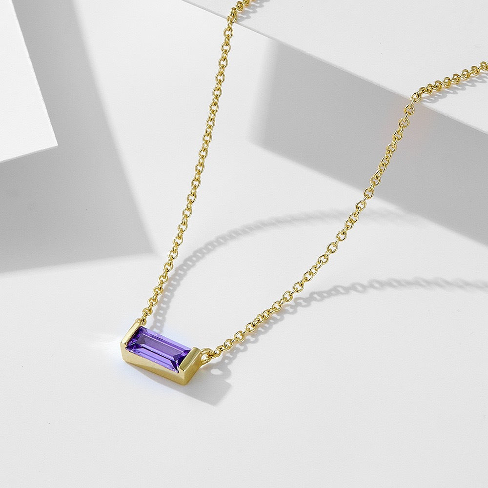 Close-up of minimalist silver clavicle chain with a sparkling square lucky stone