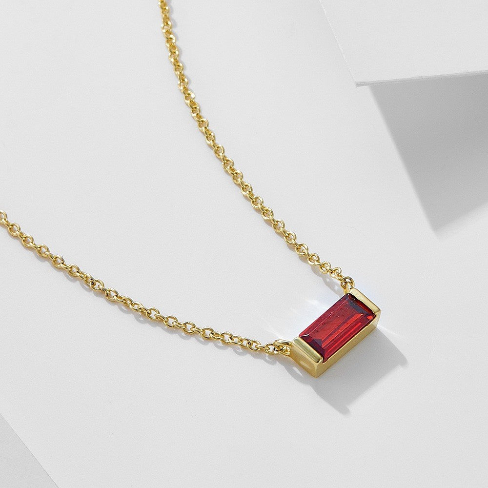 Close-up of minimalist silver clavicle chain with a sparkling square lucky stone