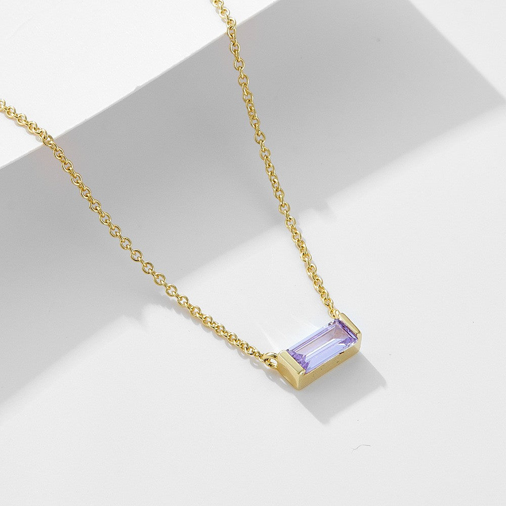 Close-up of minimalist silver clavicle chain with a sparkling square lucky stone