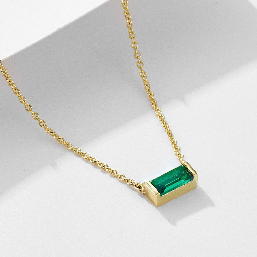Close-up of minimalist silver clavicle chain with a sparkling square lucky stone