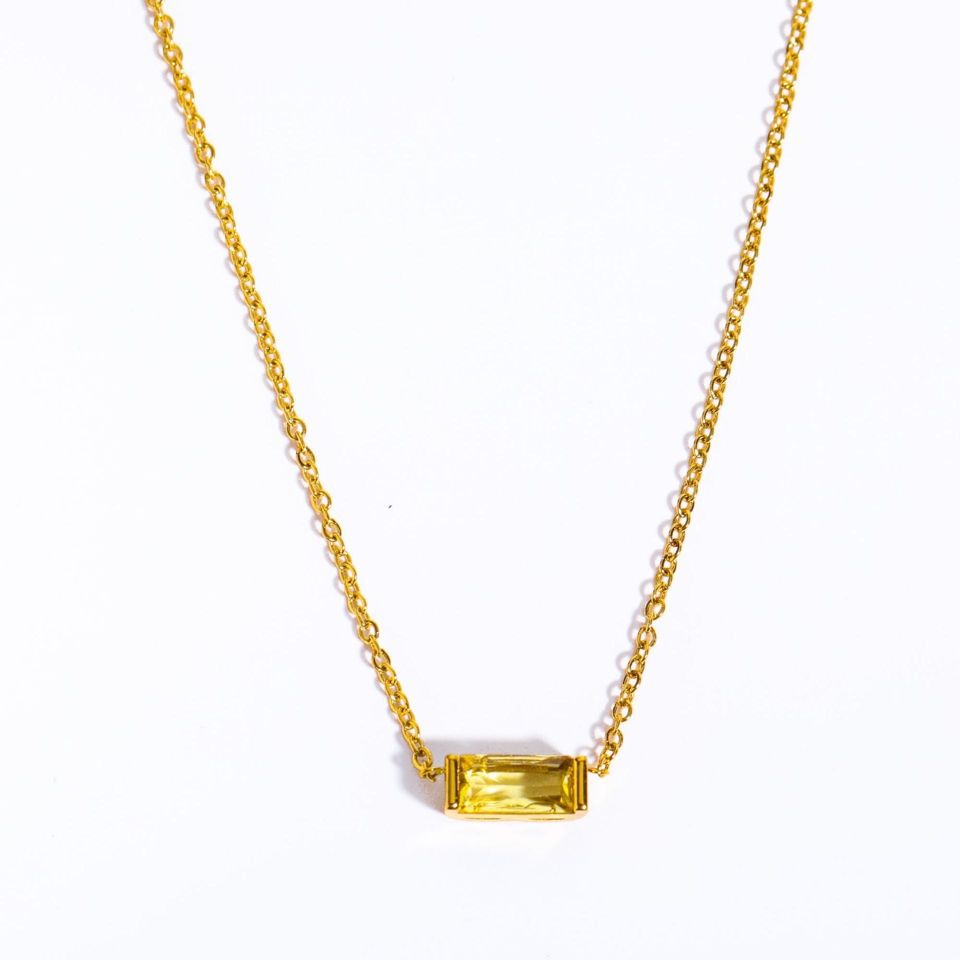 Close-up of minimalist silver clavicle chain with a sparkling square lucky stone